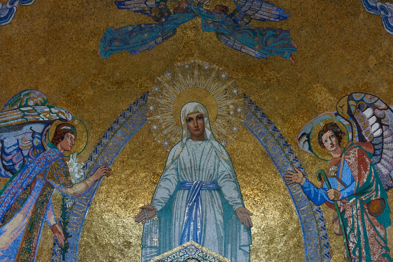 a painting of jesus surrounded by angels on a wall